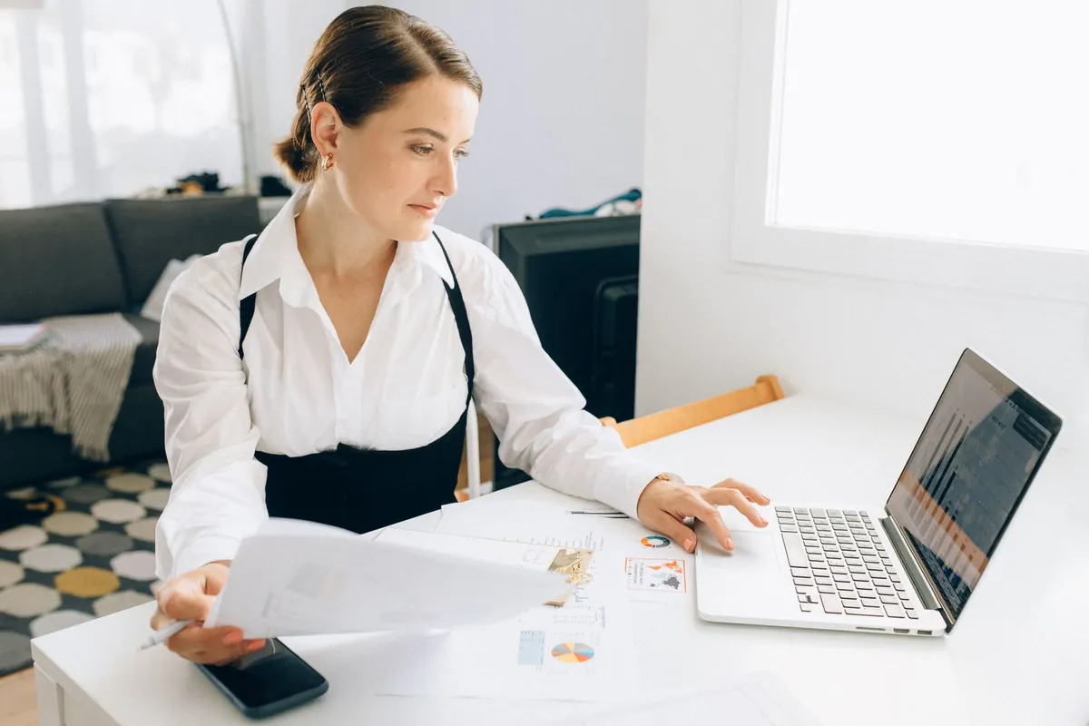How to Automate Sales Follow Up: Data, Channels and Timing Woman reviewing reports at her laptop, the data, channels and timing behind automated sales follow-up