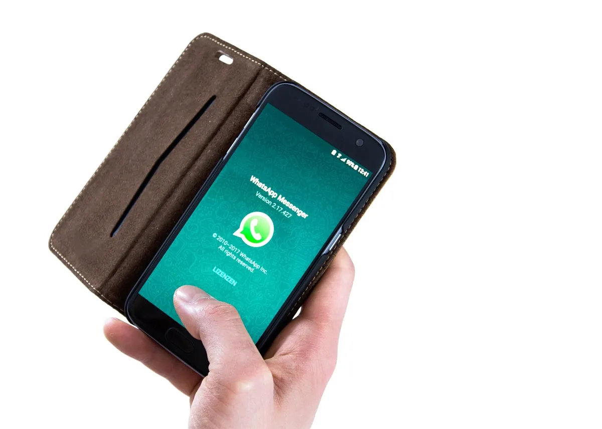 Hand holding a phone with a messaging app open