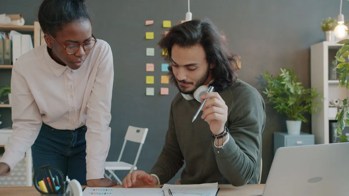 Why Staff Keep Interrupting Colleagues for Answers Two colleagues discussing work in an office, why staff keep interrupting each other